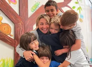 Un abbraccio tra la maestra e i bambini IEXS