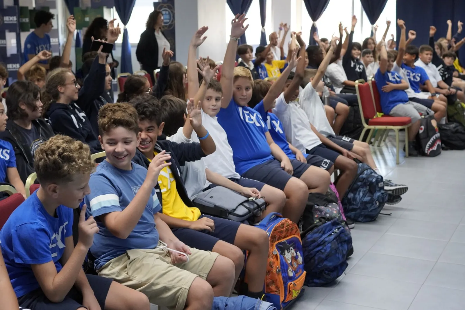 Studenti IEXS partecipano alzando la mano durante un incontro