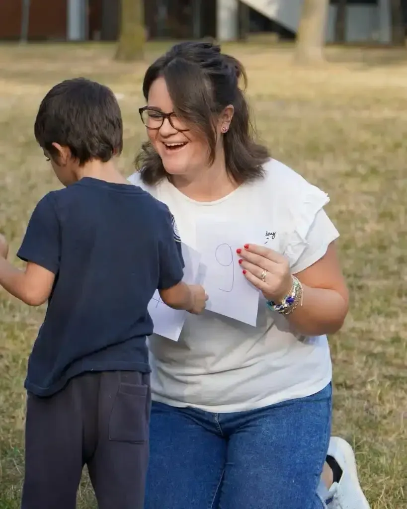 Una docente IEXS ascolta un bambino all’aperto